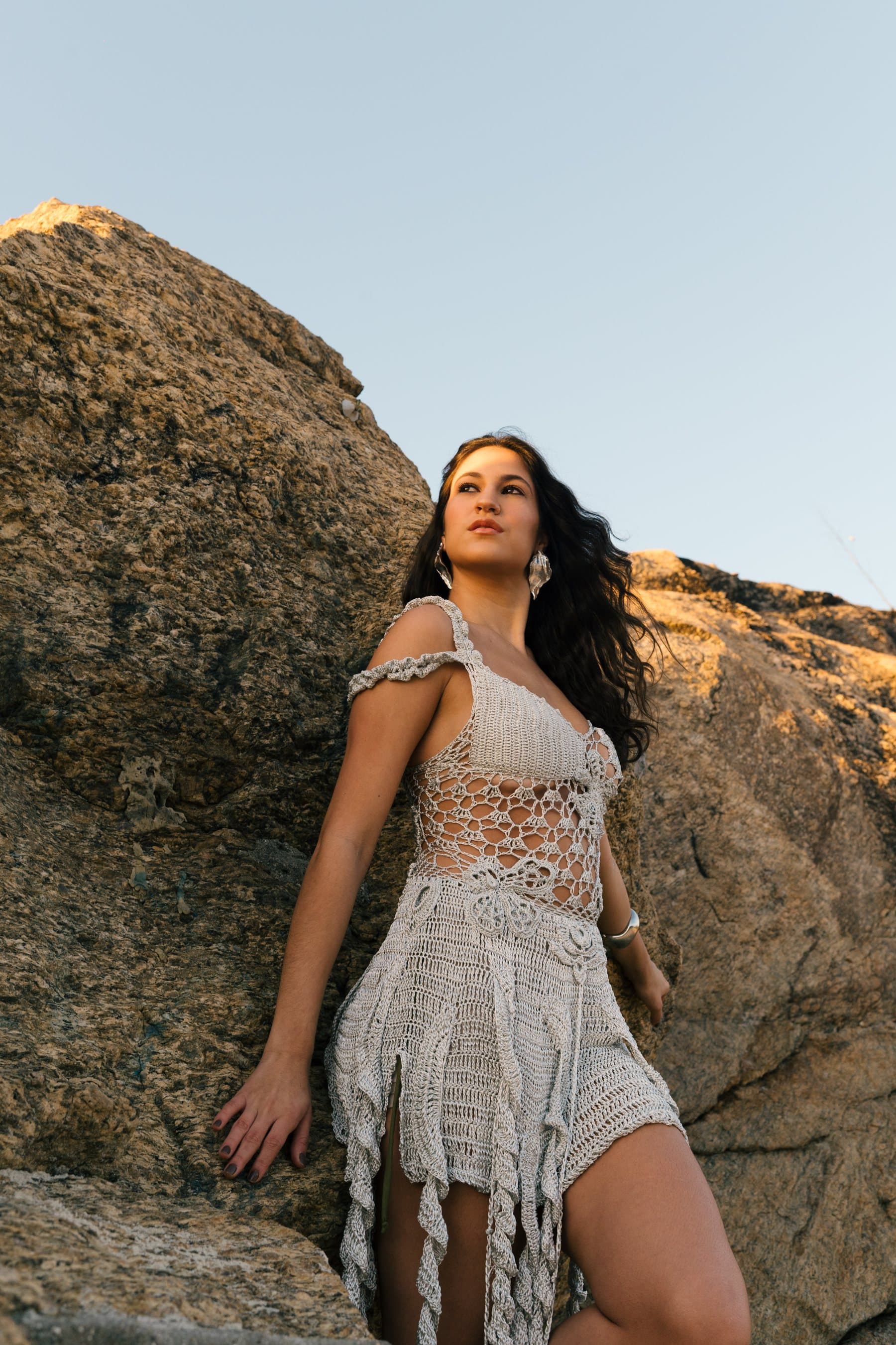 Vestido Serena em crochê Prata Radiante, com franjas longas, sobre as pedras